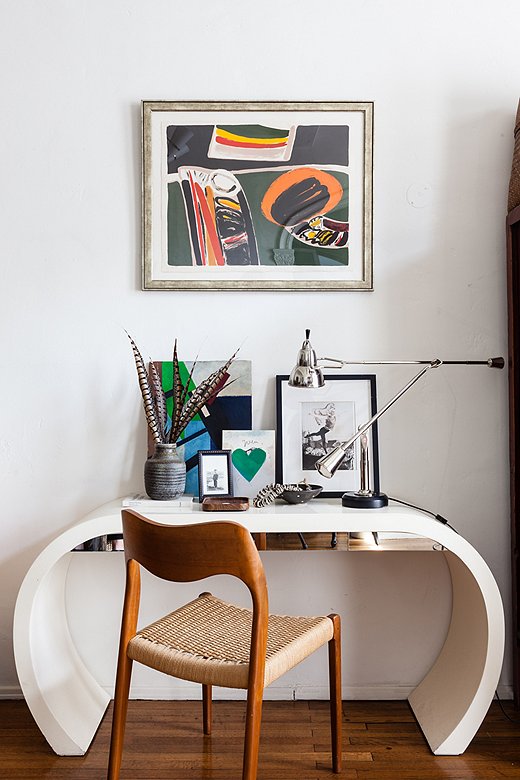 Colorful art, a gleaming lamp with a polished nickel finish, and the mirrored drawer fronts of the desk disrupt the neutral color scheme to beautiful effect. Photo by Nicole LaMotte.
